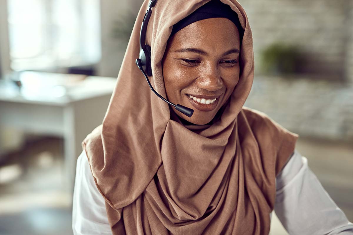 Woman wearing a hijab using a headset to answer calls