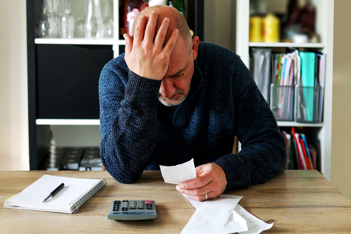 Man stressed about calculating bills and debts