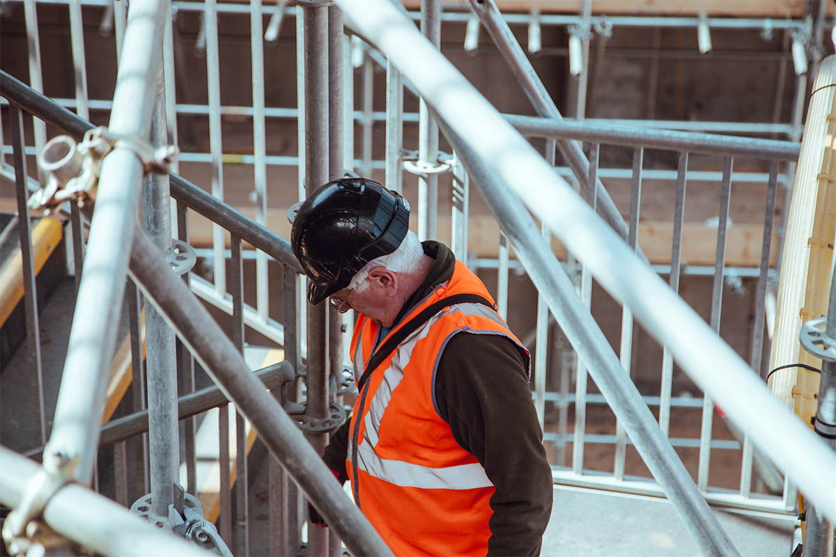 Man on a construction site wearing a hard hat and high-vis jacket