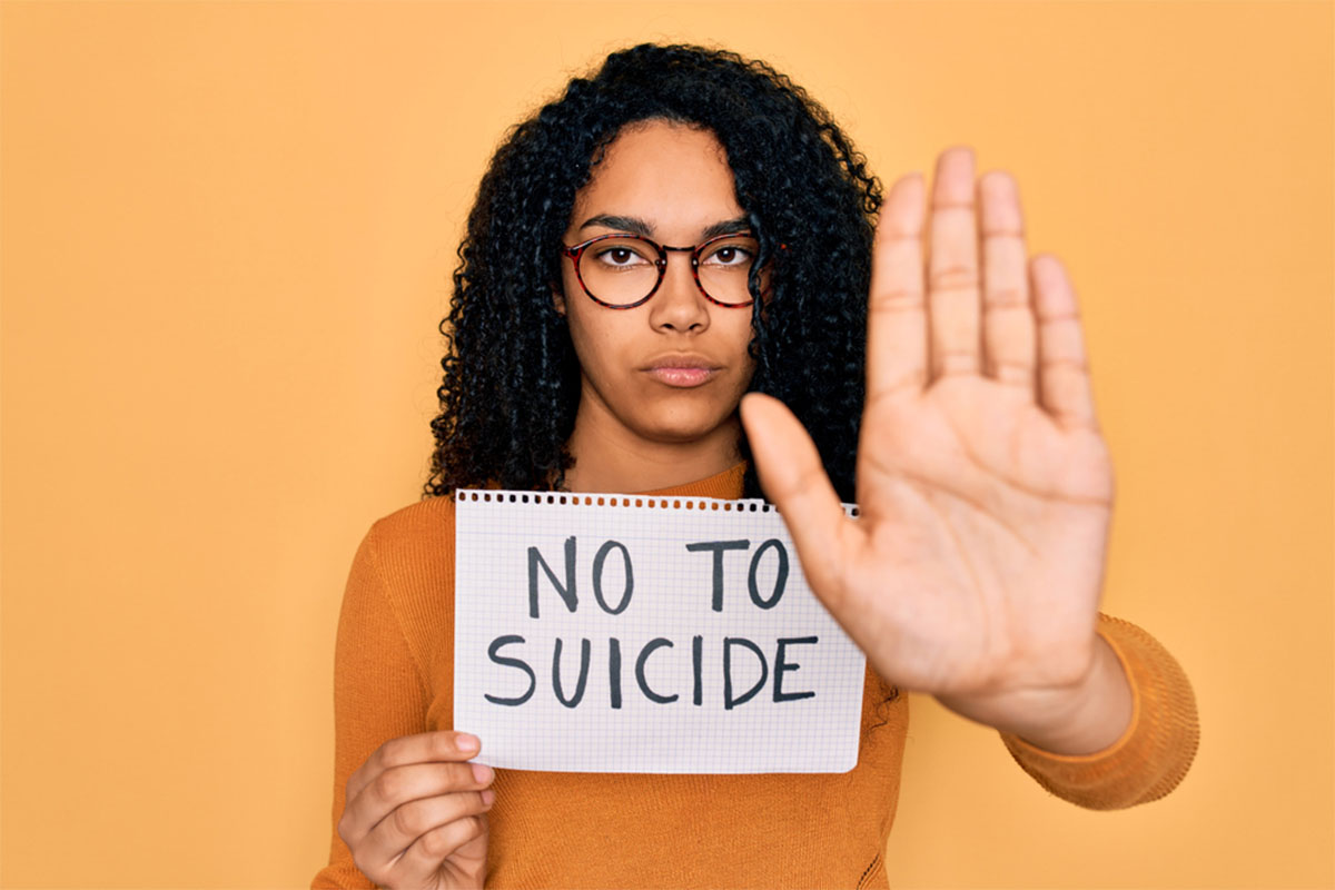 Woman holding a sign that says no to suicide