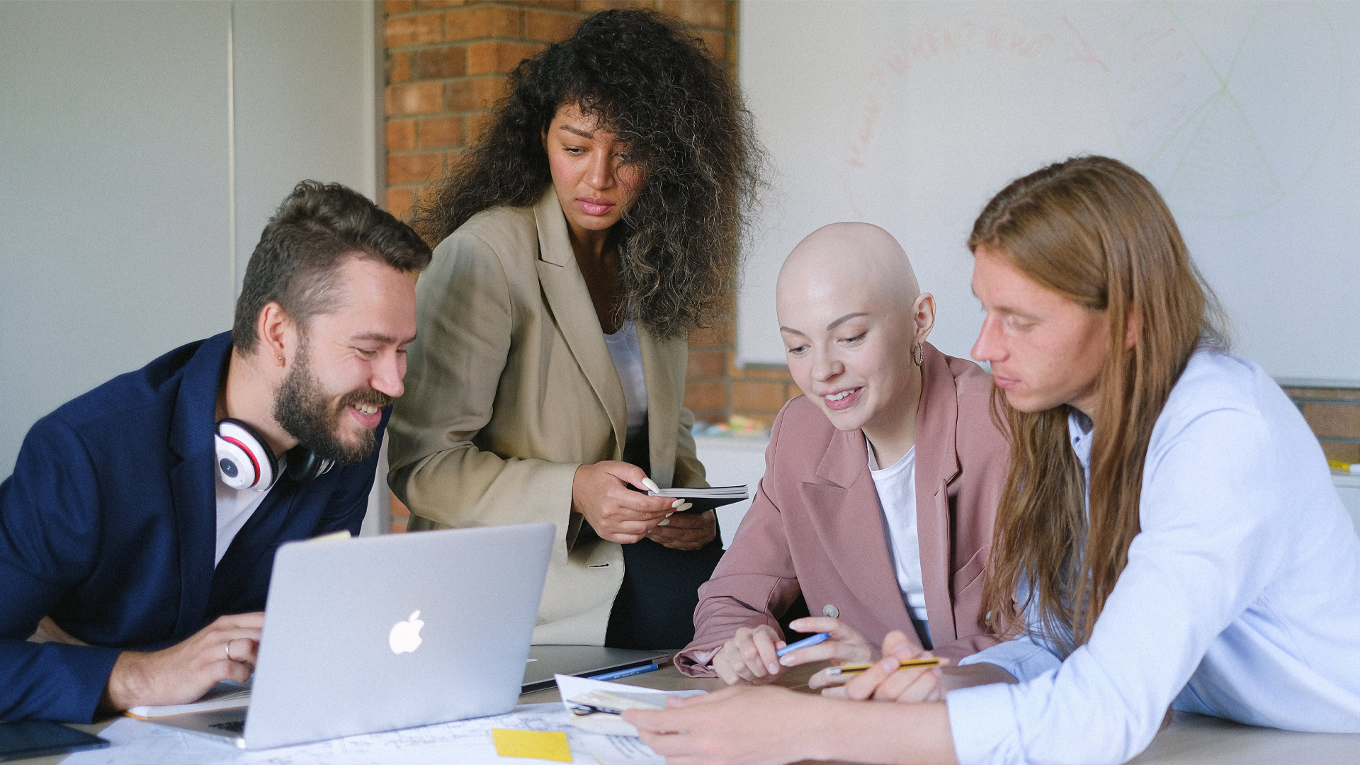 Happy work colleagues gathered around desk